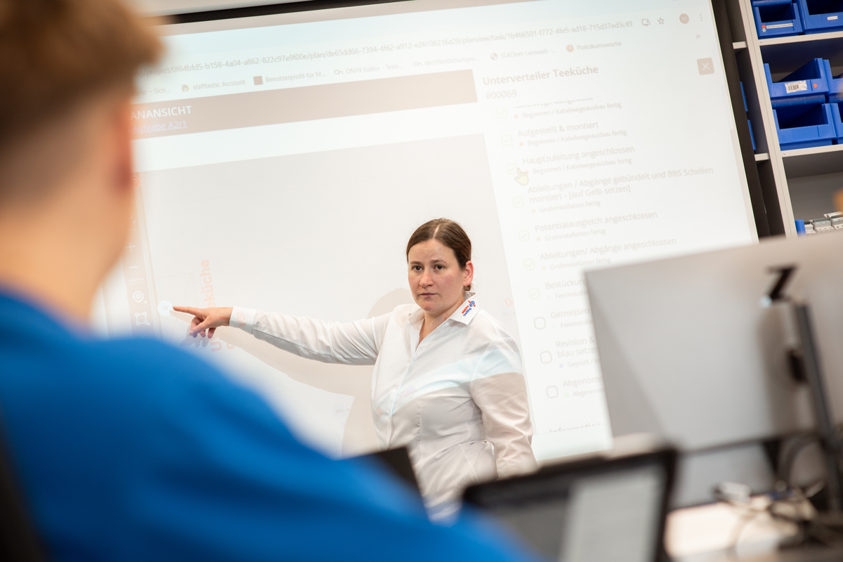 Dozentin erklärt Lerninhalte auf digitalem Whiteboard – Weiterbildung und persönliche Entwicklung über die EB-Akademie E-Learning-Plattform
