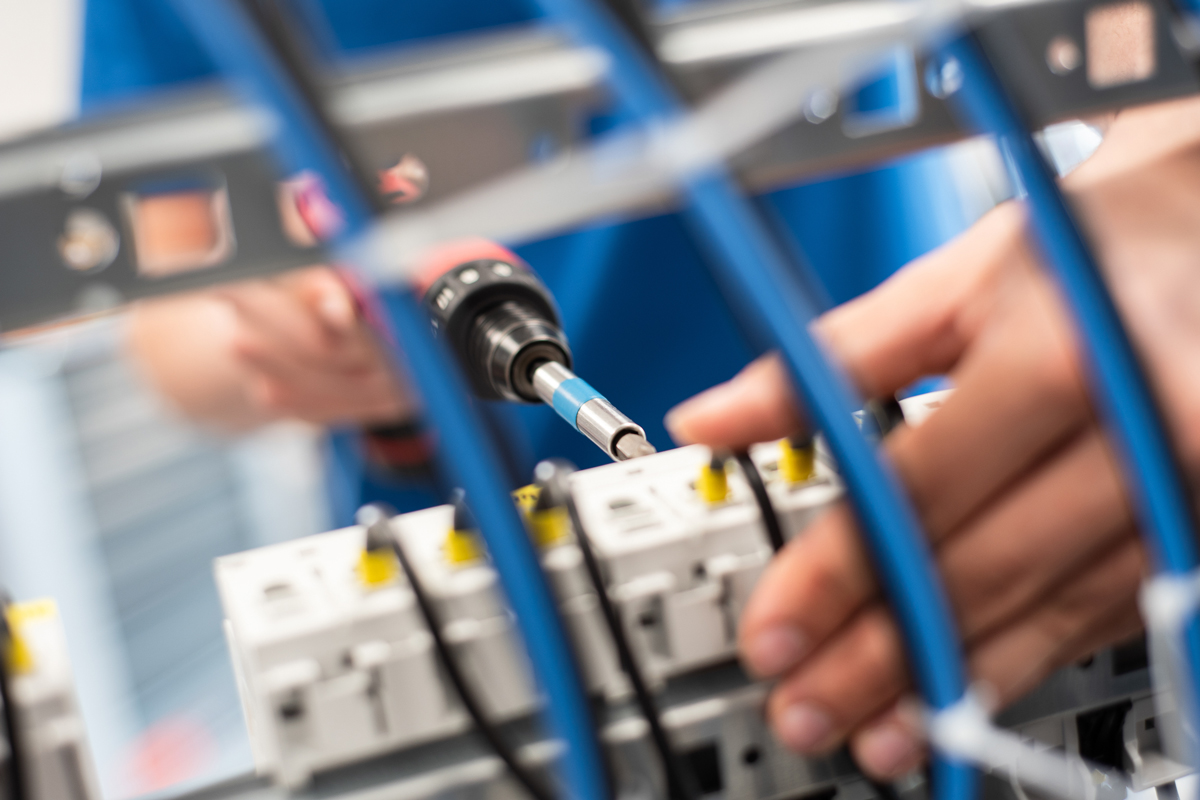 Techniker prüft Verbindung im Verteilerschrank