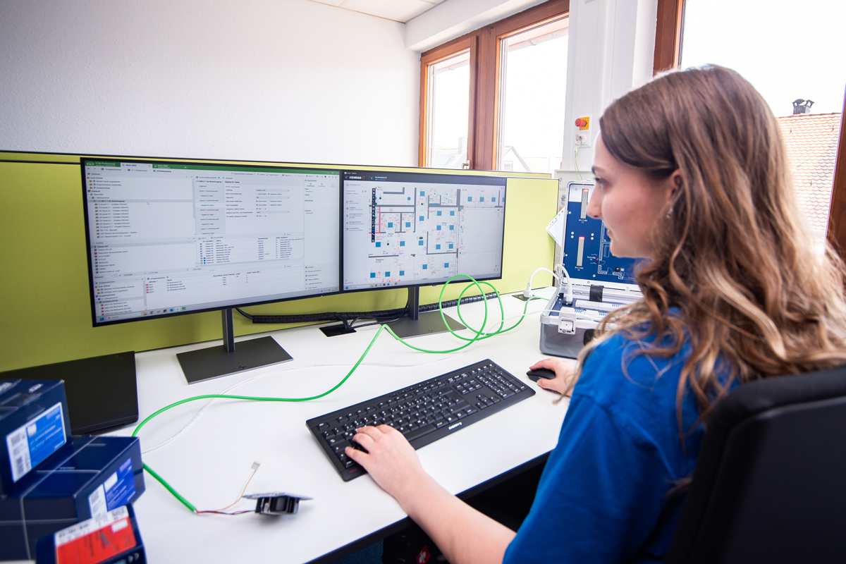 Azubi programmiert Steuerungssysteme am Doppelmonitor